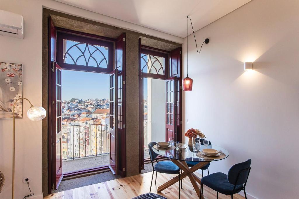 a dining room with a table and chairs and a window at Central Studio w/ AC, Views & Balcony by LovelyStay in Porto
