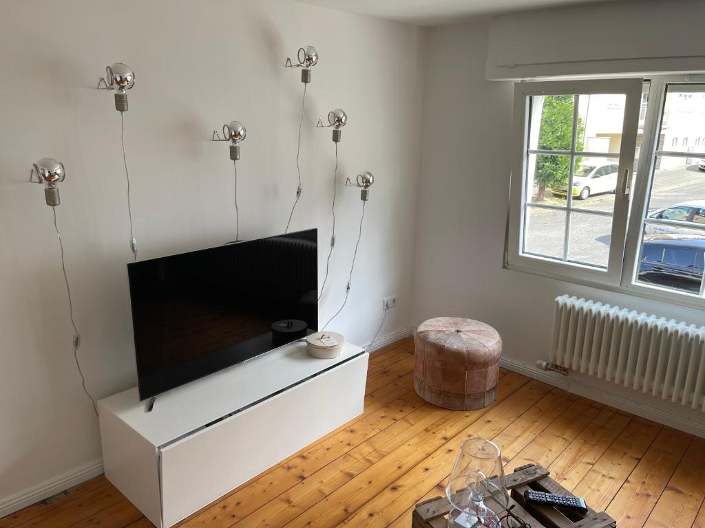 ein Wohnzimmer mit einem großen Flachbild-TV in der Unterkunft Kleines, gemütliches Haus in Bonn in Bonn