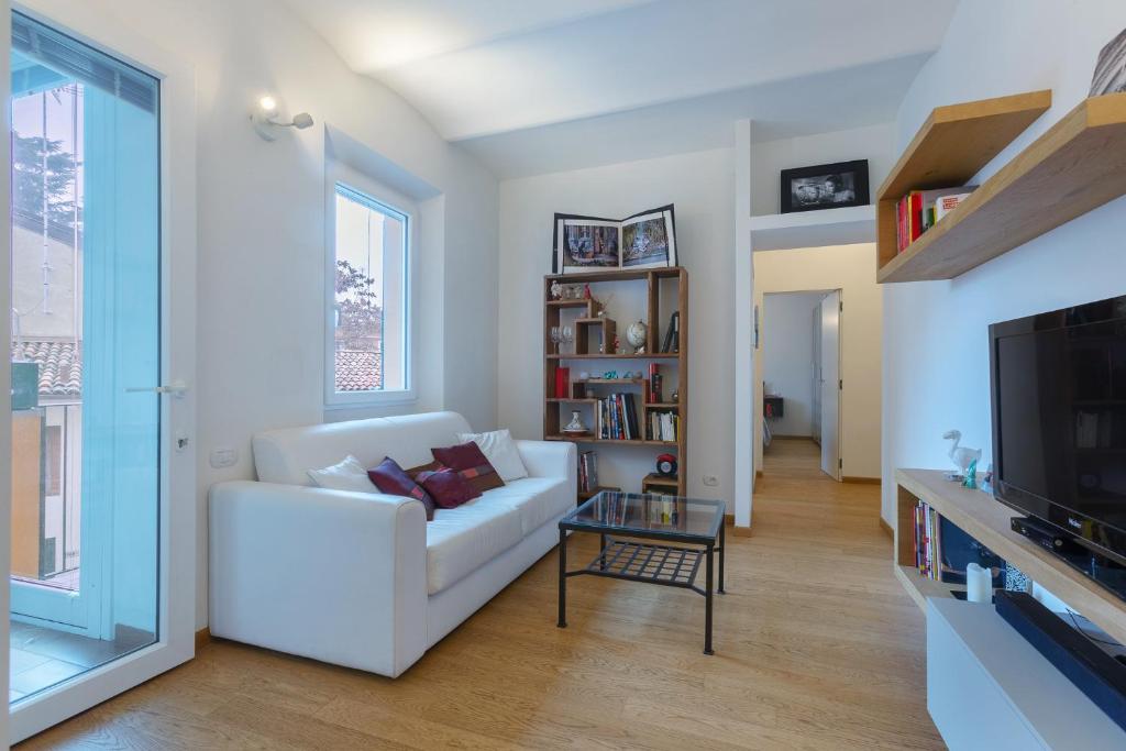 ボローニャにあるBologna Saragozza District Apartmentの白いソファとテレビのあるリビングルーム