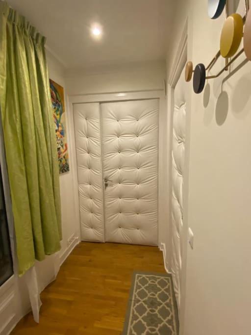 un couloir avec une porte blanche et un rideau vert dans l'établissement Premium studio 2 minutes walk from Champs-Elysees, à Paris