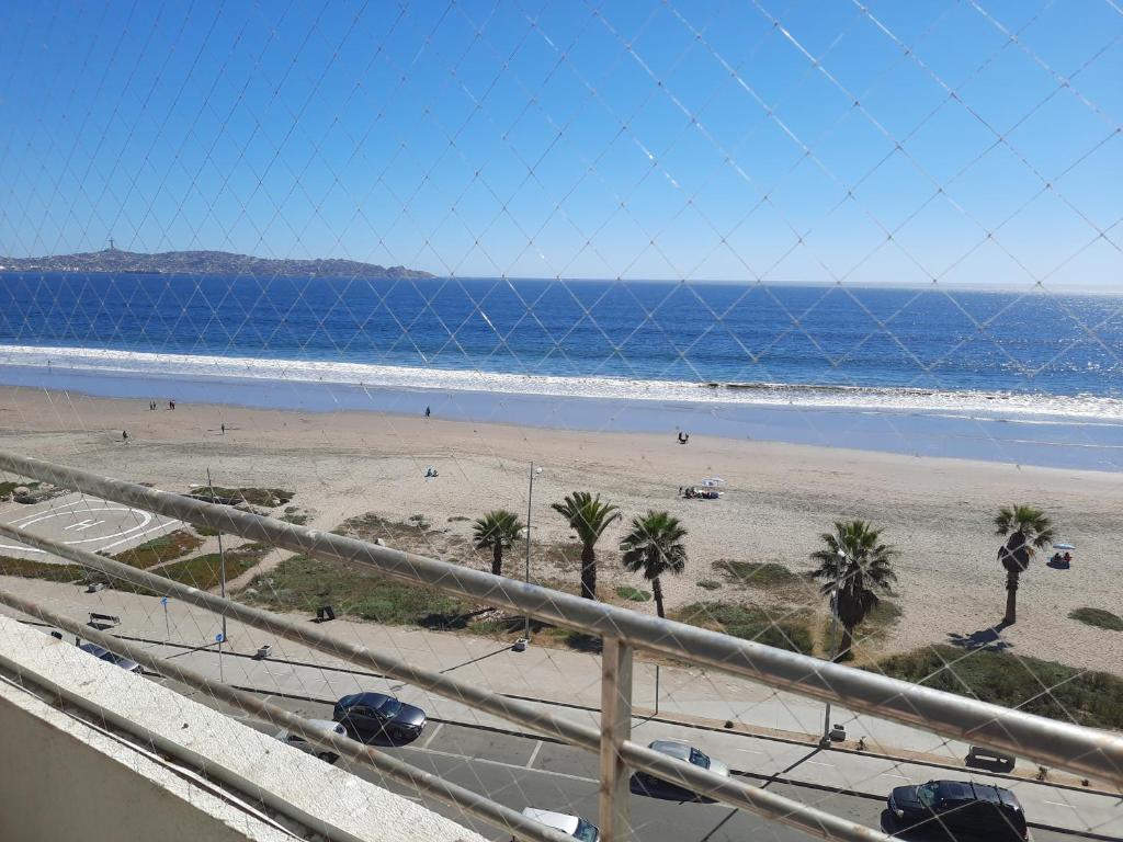 een uitzicht op een strand met palmbomen en de oceaan bij Departamento en Condominio Mar Serena in La Serena