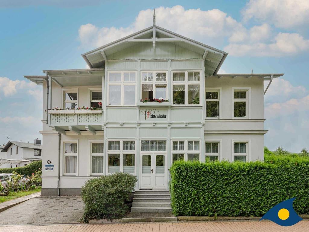 ein weißes Haus mit Balkon darüber in der Unterkunft Villa Fichtenhain Whg. 02 in Bansin