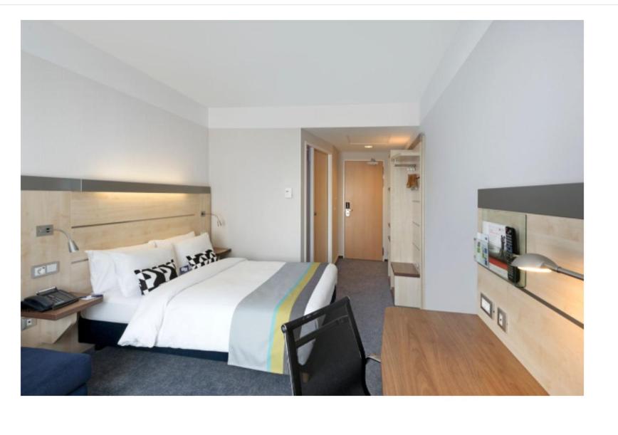 a hotel room with a large bed and a desk at Holiday Inn Express Singen, an IHG Hotel in Singen