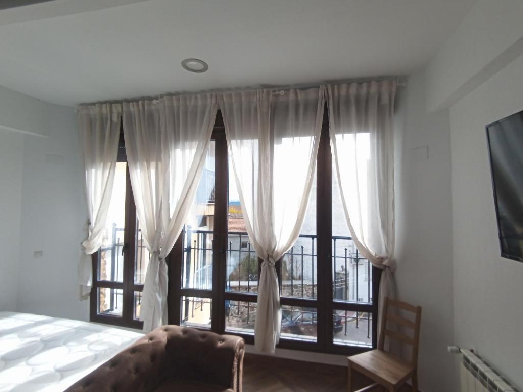 1 dormitorio con cama y ventana grande en Apartamento de lujo en la Sierra, en Becerril de la Sierra
