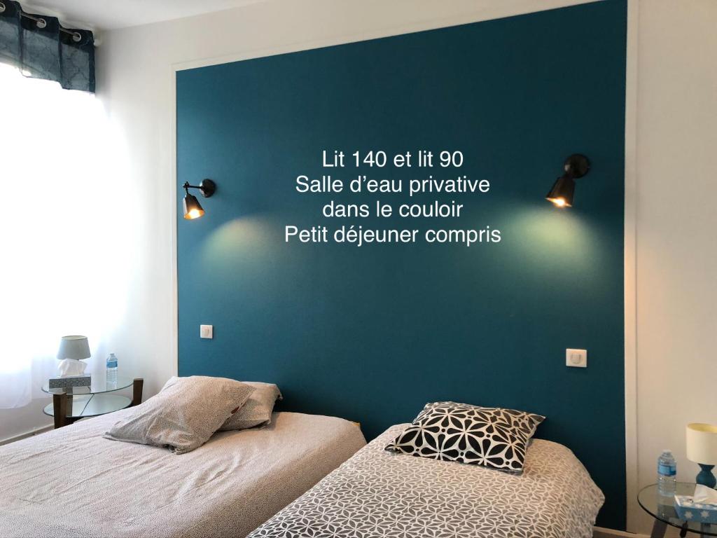 ノジャン・ル・ロトルーにあるLe 42 Chambre bleueの青い壁のベッドルーム