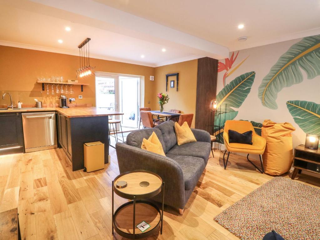 a living room with a couch and a kitchen at Feus Holiday Cottage in Auchterarder