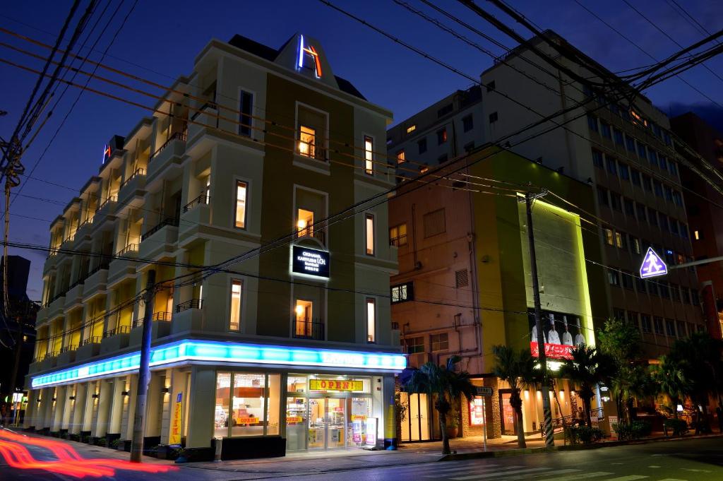 a building on the corner of a street at night at Kariyushi LCH. Izumizaki Kencho Mae in Naha