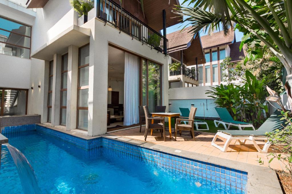 a house with a swimming pool and a table and chairs at Luxury Villa Goa in Candolim