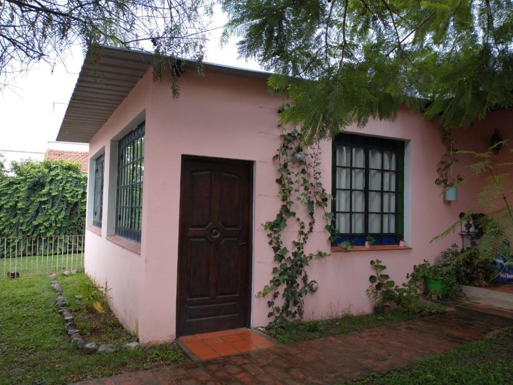 a small pink house with a brown door at El Remanso in San Lorenzo