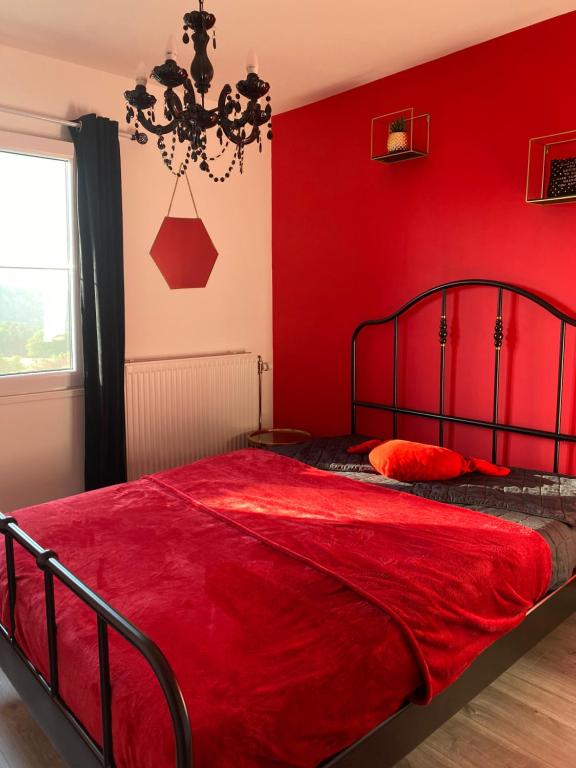 una camera da letto con pareti rosse e un letto con una coperta rossa di Sol Borsay - Studio de vacances à la campagne - Idéal pour 2 a Comblain-au-Pont