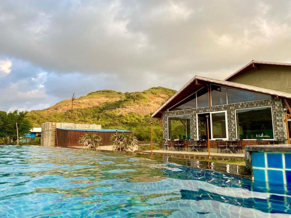 um resort com piscina em frente a uma casa em Mastiff Grand La Villae em Lonavala