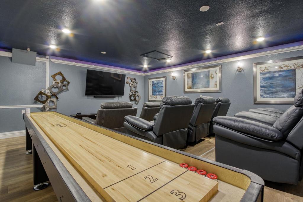 ein Spielezimmer mit einem Billardtisch und Stühlen in der Unterkunft Disney Daze Villa - 5 bed Windsor Hills pool home in Orlando