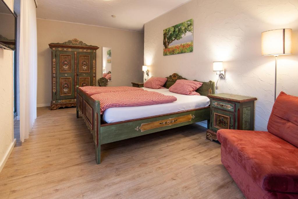 a bedroom with a large bed and a couch at Landhotel-Restaurant Beckmann in Heiden