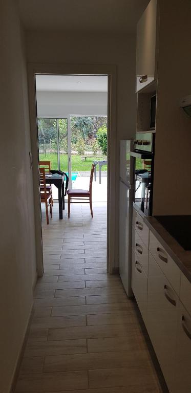 a kitchen with a view of a table and a patio at Le Narval-appartement 5 in Calcatoggio