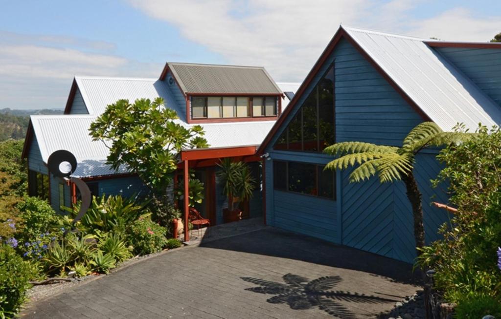una casa azul con techo de metal en Titore Lodge, en Russell