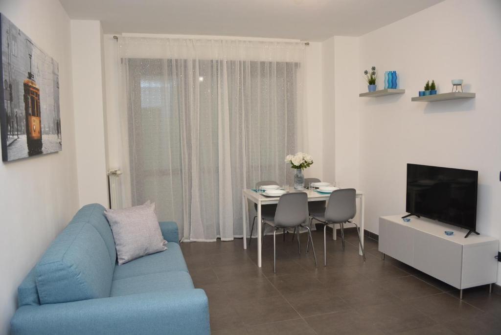 - un salon avec un canapé bleu et une table dans l'établissement Ginevra Home, à Sesto San Giovanni