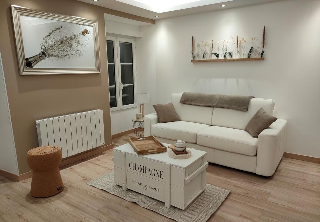 a living room with a white couch and a table at Gîte "La bulle de Léna" avec petit-déjeuner garage et parking in Flavigny