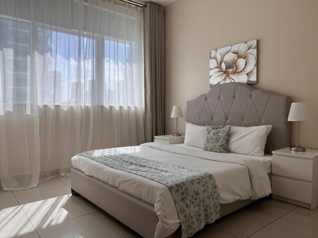 a bedroom with a large bed with a large window at Two Continents Holiday Homes - Two steps to Marina Walk in Dubai