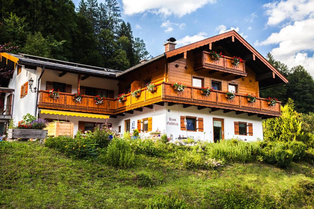 une maison avec des fleurs sur ses balcons dans l'établissement Gästehaus Göllblick, à Bischofswiesen