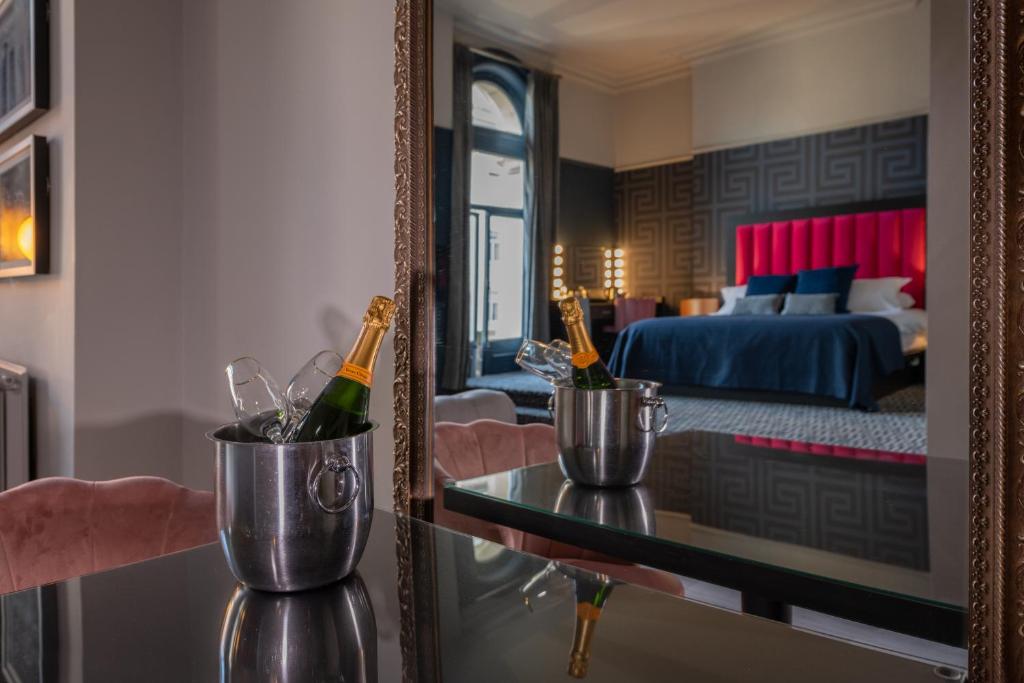 a room with a mirror and champagne bottles on a table at 62 Castle Street Hotel in Liverpool