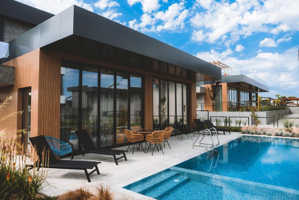 a house with a swimming pool next to a building at Cabo Villas in Arapya