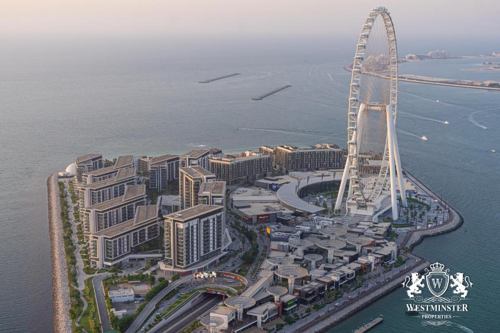 an aerial view of a city with a ferris wheel at Westminster JBR in Dubai