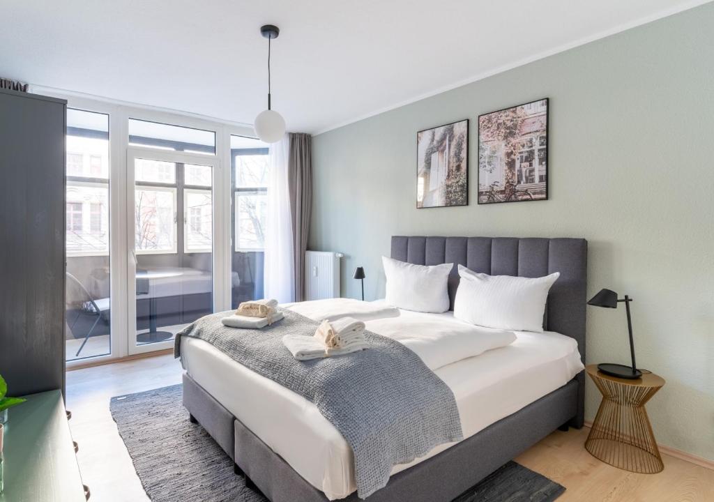 1 dormitorio con cama grande y ventana grande en limehome Magdeburg Breiter Weg en Magdeburgo