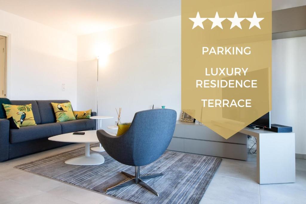 un salon avec un canapé et une chaise dans l'établissement Renovated 2-Br Apartment with Terrace and Pool, à Cannes
