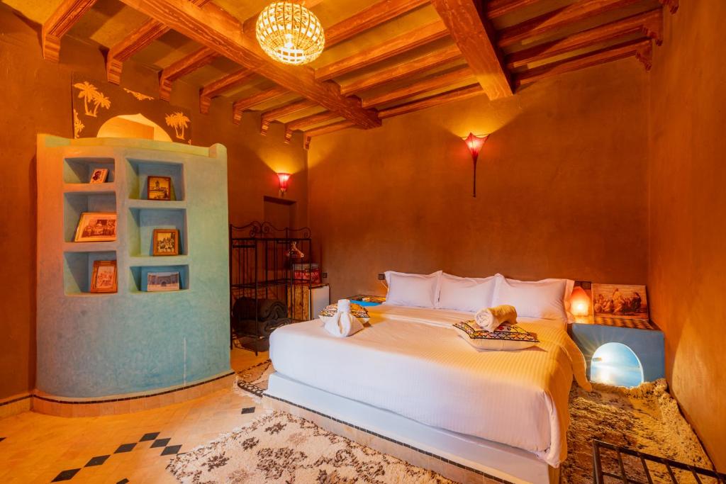 um quarto com uma grande cama branca num quarto em Kasbah Hotel Ziz Palace Rissani em Rissani