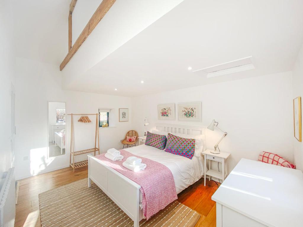 a white bedroom with a bed and a table at Polly's Yard Dennington Suffolk in Dennington