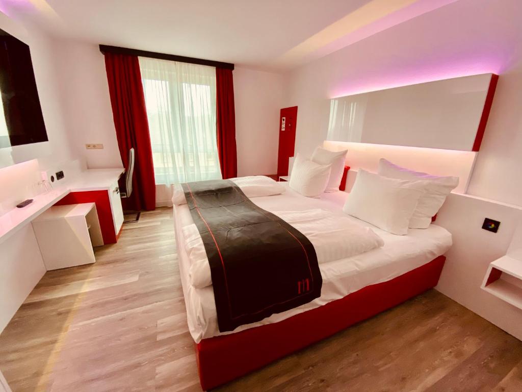 Habitación de hotel con cama grande y baño. en DORMERO Hotel Bretten, en Bretten