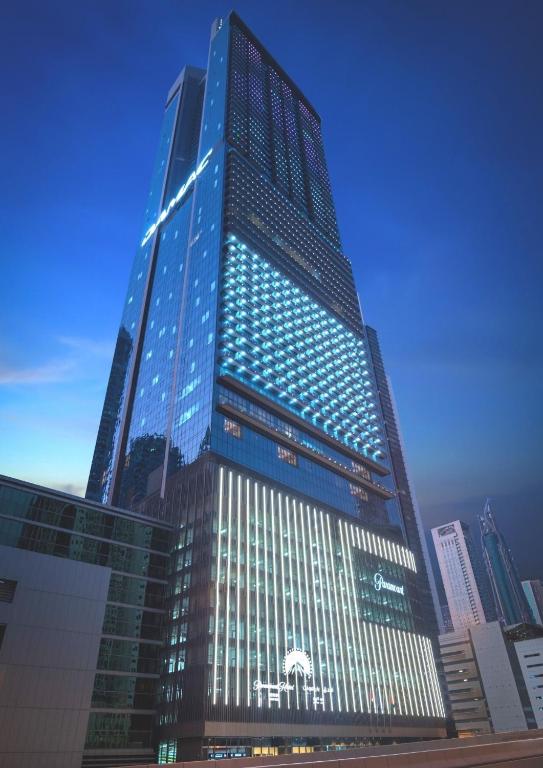 a tall building with blue lights on it at Paramount Hotel Midtown in Dubai