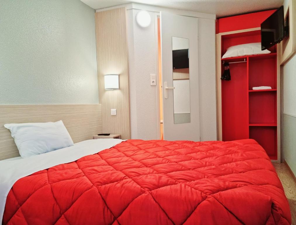 una camera con un letto rosso e una coperta rossa di Premiere Classe Honfleur a Honfleur