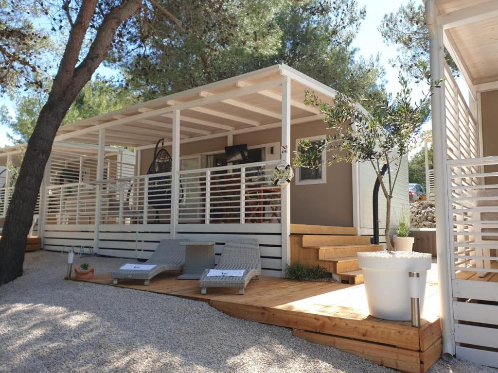 a pergola with two chairs on a wooden deck at Seamoon home in Jezera