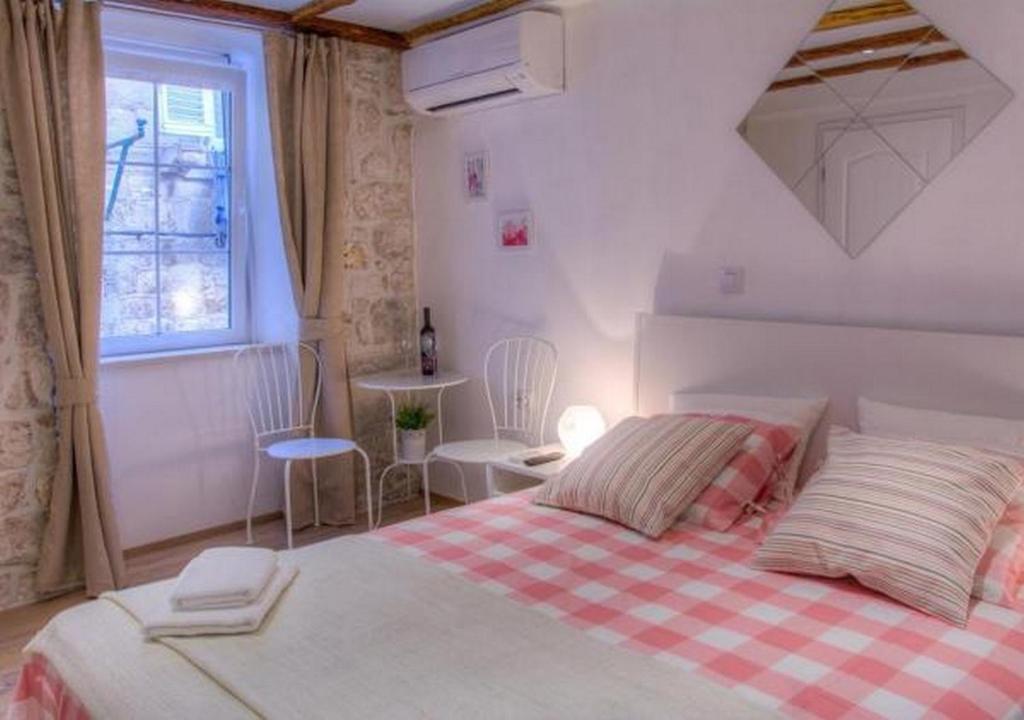 1 dormitorio con 1 cama con manta roja y blanca a cuadros en Two Friends Dubrovnik Palace, en Dubrovnik