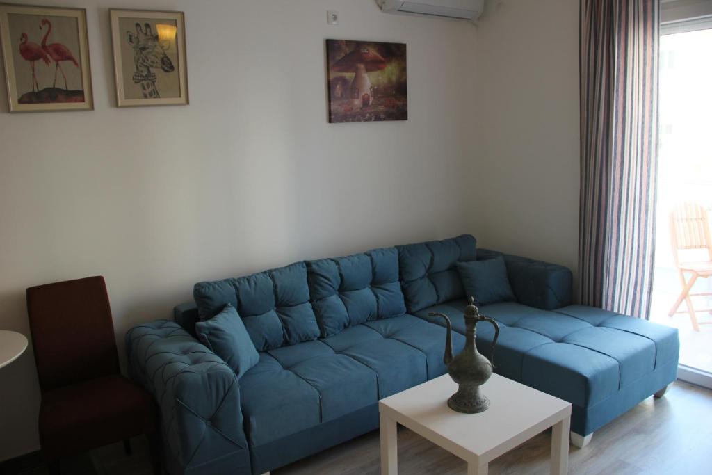 Sofá azul en la sala de estar con mesa en Apartmani ANTEL 5*, en Banja Koviljača