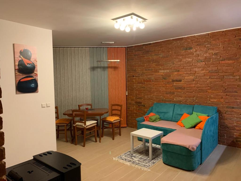 a living room with a couch and a brick wall at Izzi apartma in Kranjska Gora