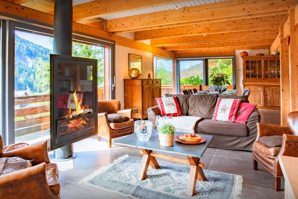 a living room with a couch and a fireplace at Chalet Musini - OVO Network in Le Grand-Bornand