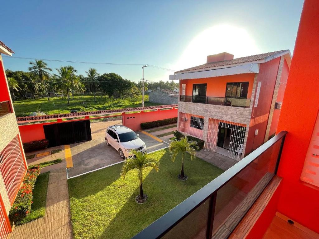an apartment balcony with a car parked in a parking lot at Casa Lua Cheia na Praia de Peroba, Maragogi in Maragogi