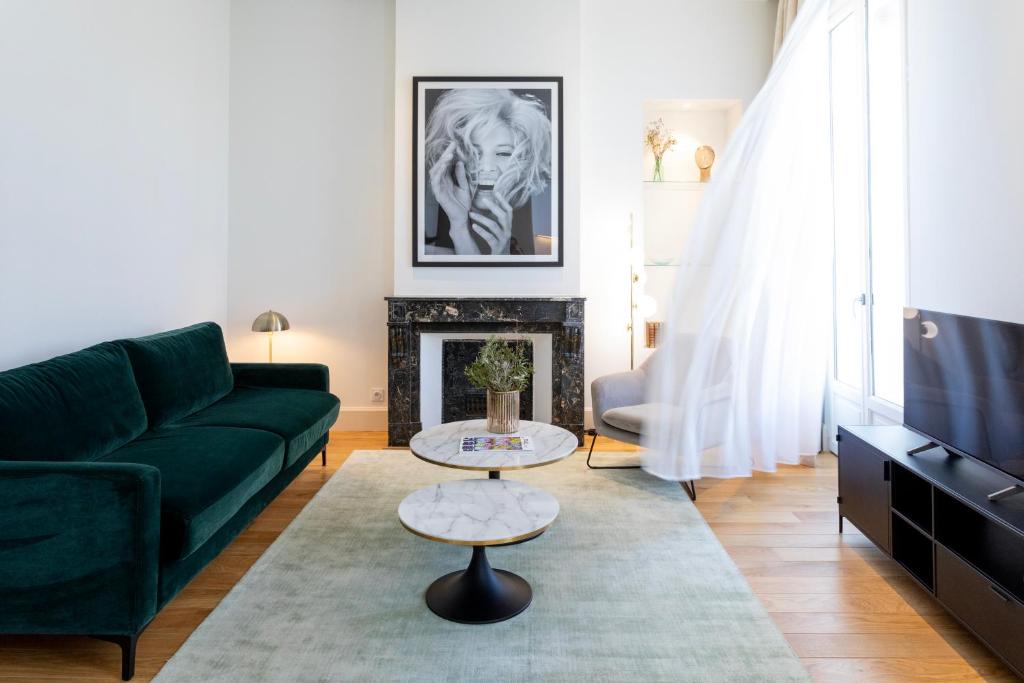 a living room with a green couch and a fireplace at Les Clés Secrètes in Sète