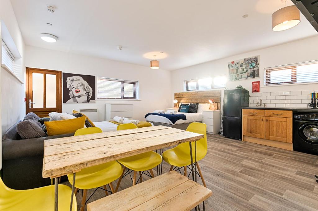 a kitchen and living room with a table and yellow chairs at The Nest - with Parking! in Swansea