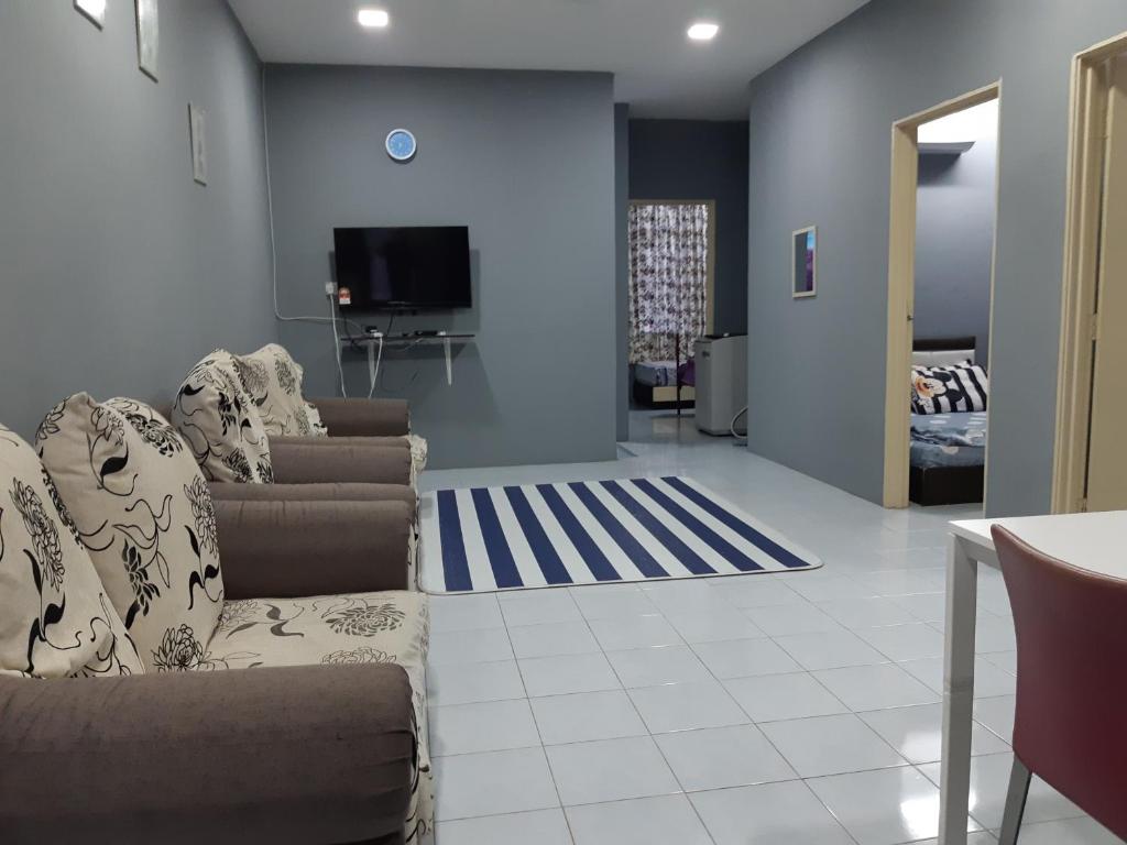 a living room with a couch and a tv at Anis Homestay Gua Musang in Gua Musang
