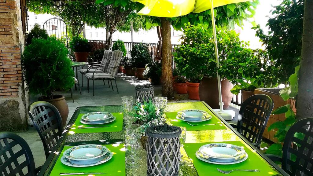una mesa verde con platos y vasos encima en Las Glicinias en Casas del Castañar