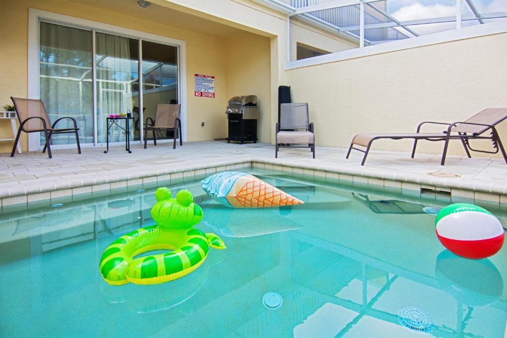 - une piscine avec un jouet gonflable dans l'eau dans l'établissement Serenity Resort 3 Bedroom Vacation Townhome with Pool (2008), à Clermont