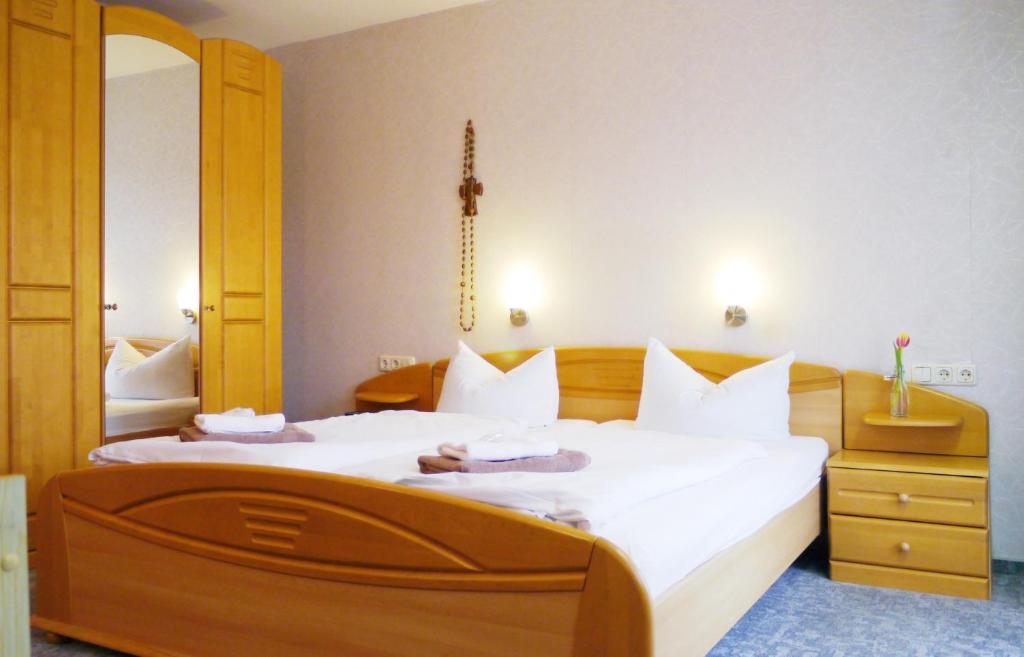 1 dormitorio con 1 cama grande con sábanas blancas en Landgasthof Zum Hirschen, en Kemnath