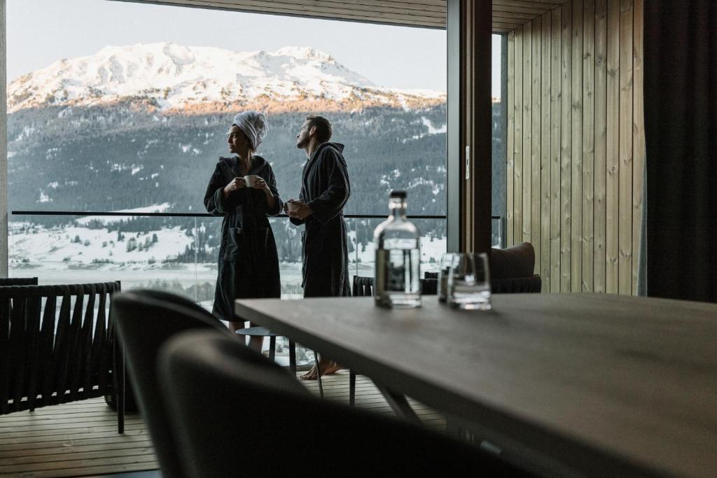 zwei Frauen, die vor einem Tisch mit Aussicht stehen in der Unterkunft Lacumontes Lake View Apartments in Graun im Vinschgau