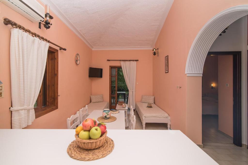 Cette chambre comprend une table et une corbeille de fruits. dans l'établissement Alykes Park Bungalows, à Alykes