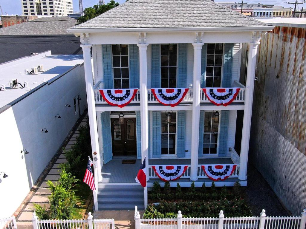 Una casa blu con bandiere americane sopra. di The White House Galveston a Galveston