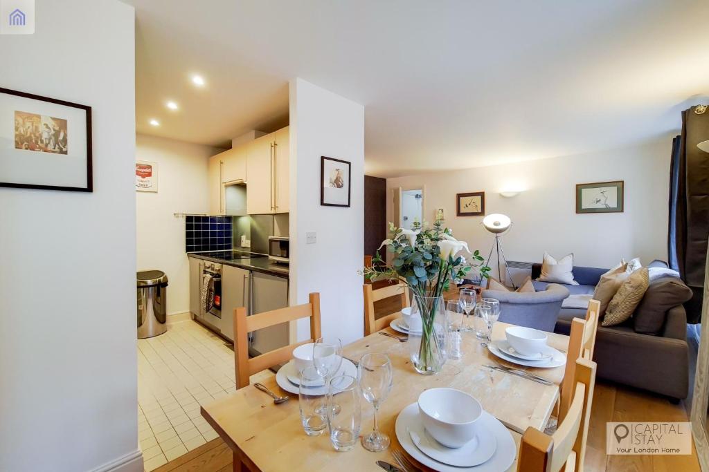 a dining room and living room with a table and chairs at Capital Stay Aldgate - Two bed Apartment in London