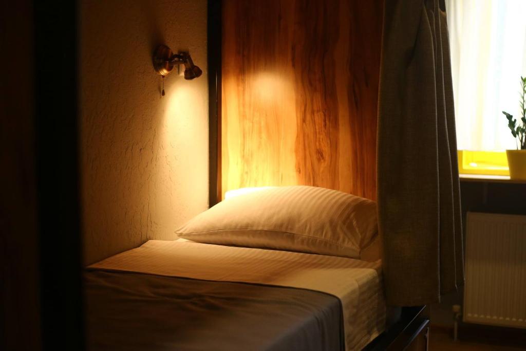 Cama pequeña en habitación con ventana en Hostel Nomad en Tiflis